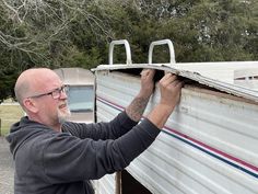 a man is fixing the roof on a trailer