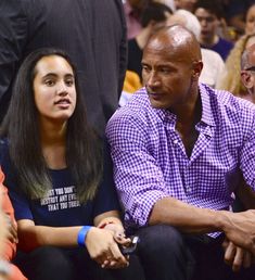 a man and woman sitting next to each other at a basketball game