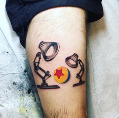 a tattoo on the leg of a man with two lamps and a star in it