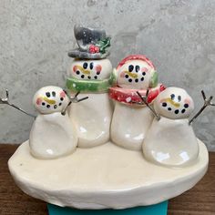 a group of snowmen sitting on top of a white plate next to each other