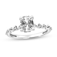 a white gold engagement ring with an oval cut center stone and pave set shoulders