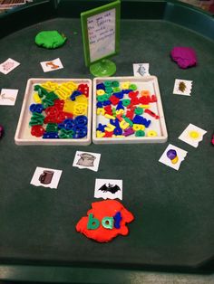 two trays filled with colorful plastic letters and magnets on top of a table