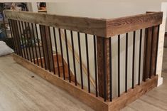 a wooden banister with metal handrails on the floor next to a white wall