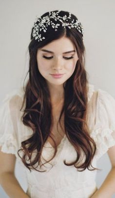 a woman with long hair wearing a white dress and a tiara on her head