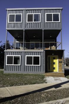 a two story house made out of shipping containers