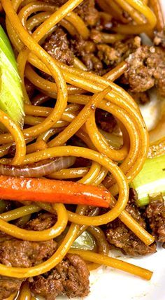 a plate with noodles, meat and vegetables on it is shown in close up view