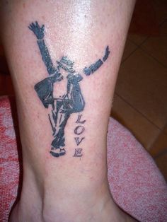 a person with a tattoo on their leg that says love and is holding his arms up