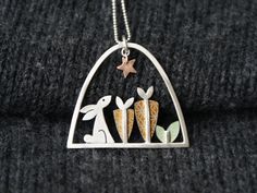 A quirky necklace featuring a little rabbit or hare, with a line of carrots and a little copper star, hand crafted from sterling silver and aluminium.  The framework is made from sterling silver square wire and the coloured pieces are anodised aluminium which is blind riveted to the silver. The pendant is hung from an 18 inch sterling silver chain. The pattern on the aluminium is created digitally and applied as a resist. The metal is then dyed and sealed and the resist removed leaving the patte Carrot Necklace, Rabbit And Carrot, Rabbit Jewelry, Silver Metal Clay, Handmade Silver Jewellery, Metal Clay, Metal Crafts, Clay Jewelry, Rabbits