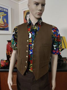 This vest is well made in a golden brown wool with a six button closure with pearly buttons and chest and hip pockets. It also has a wool reverse and acetate lining. The condition is good except for a pinhole on the front ( see photo) Size is small. Measurements are Chest 92cm Length 55cm Brown Workwear Vest With Buttons, Brown Vest With Button Closure For Work, Fitted Brown Vest With Button Closure, Tailored Brown Vest With Button Closure, Brown Wool Vest For Workwear, Fitted Brown Wool Vest, Brown Wool Vest For Work, Brown Buttoned Vest For Formal Occasions, Brown Formal Vest With Buttons