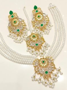 Add a touch of elegance and glamour to your attire with this stunning Shibra Mini Mala Zircon Necklace Set from My Jewel Box. The exquisite set includes a beautiful necklace, matching earrings and a Tikka that boast natural, multiple gemstones set in gold-coloured alloy. The jewellery set is perfect for special occasions like engagements, weddings, anniversaries, birthdays and Valentine's Day. The set's intricate design and excellent cut grade make it a must-have piece of Indian/Pakistani Bridal Elegant Kundan Bridal Sets For Eid, Elegant Kundan Hand Set, Elegant Kundan Sets With Intricate Design, Elegant Meenakari Bridal Sets For Eid, Elegant Bridal Sets For Eid Festivities, Elegant Zari Work Necklace For Eid, Elegant Bridal Sets For Eid, Elegant Jewelry With Zari Work For Eid, Elegant Jewelry With Zari Work For Reception