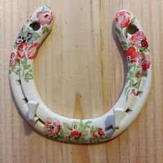 a flowered horseshoe hangs on a wooden wall