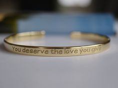 "Our Gold plated bracelets are coated with 22K gold and the thickness of the gold layer is 0.5 microns. It's sufficient even for jewellery pieces that are exposed to rough wear. There is no way that the colour will wash off or tarnish. - Narrow bracelet engraved with your chosen message. - The thickness of gold plating is around 0.5 microns - Text, coordinates, numbers or handwriting outside and inside the cuff - The bracelet doesn't tarnish, the color doesn't wear off - Up to 90 characters on e Inspirational Gold Bracelet, Hand Stamped, Inspirational Gold Bracelet Hand Stamped, Inspirational Engraved Bangle Bracelets, Inspirational Gold Name Bracelet For Personalized Gift, Inspirational Engraved Bangle Bracelet, Inspirational Hand Stamped Gold Bracelet, Meaningful Hand Stamped Gold Bracelet, Inspirational Engraved Text Bracelets For Gifts, Gold Bracelets With Engraving Option For Promise