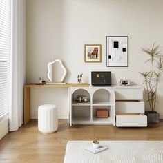 a living room with white furniture and wood flooring, including a desk that has a laptop on top of it