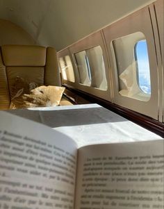 an open book sitting on top of an airplane seat