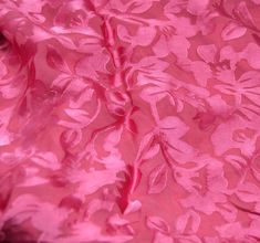 a pink fabric with flowers and leaves on it