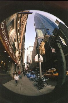 a person walking down a street next to tall buildings