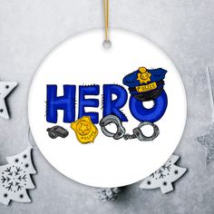 a white ornament with the word hero on it and handcuffs hanging from it