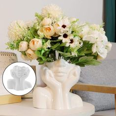 a vase filled with white flowers on top of a table next to a notepad