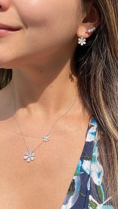 "Bring the beauty of springtime to your everyday looks with this dainty diamond daisy necklace. Set along an elegant cable chain, the flowers in this piece give off just the right amount of sparkle. -14K gold weighing 3.48 grams -144 round single cut diamonds totaling 0.34 carats are pave-set -2 round full cut diamonds totaling .05 carats - G-H in color and SI1-SI2 in clarity. - Available in rose, yellow, & white gold. Item no. N10322 The large daisy measures about 15 millimeters wide by 15 Diamond Flower Necklace, Nameplate Necklace Gold, Flower Necklace Gold, Large Daisy, Diamond Monogram, Diamond Bar Necklace, Dainty Diamond Necklace, Flower Charm Necklace, Daisy Necklace