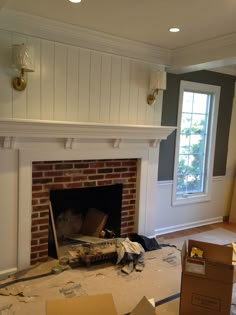 an empty room with a fire place and boxes on the floor