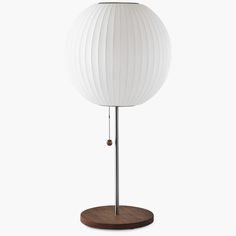 a white lamp sitting on top of a wooden stand