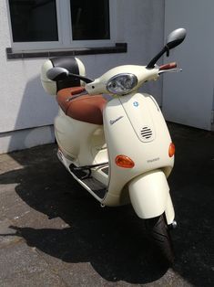 a white scooter parked in front of a building