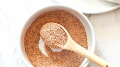 a wooden spoon in a white bowl filled with brown sugar and cinnamon on a table