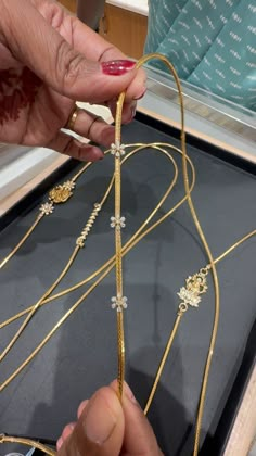 a woman is working on some gold jewelry