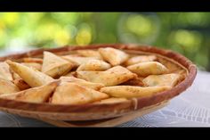 a wooden bowl filled with dumplings on top of a table