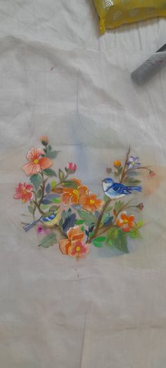 an embroidered piece of cloth with flowers on it and a pair of scissors next to it