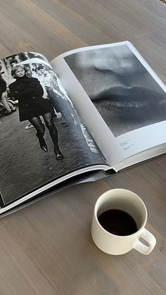 an open book on a table with a cup of coffee next to it and a photo of a woman running