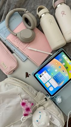 an assortment of personal items laid out on top of a bed next to a laptop