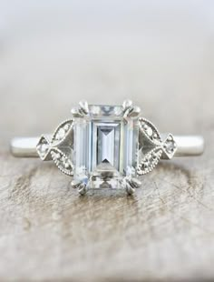 an emerald cut diamond ring with filigree accents