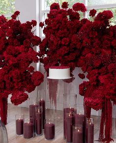 red flowers and candles are arranged on the floor