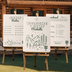 three eases with signs on them in front of a log building and grass area