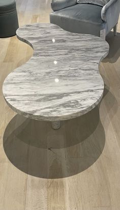 a marble coffee table sitting on top of a hard wood floor