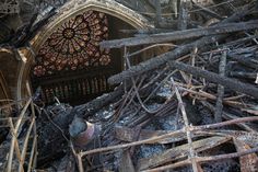 the interior of a burned out building with lots of wood and debris around it on fire