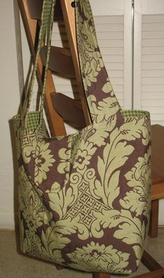 a brown and green bag sitting on top of a wooden rocking chair next to a table