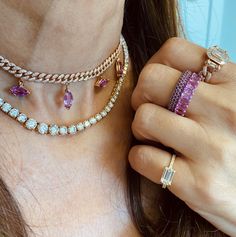 a close up of a person wearing rings and necklaces