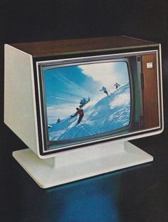 an old television with skiers on the screen is sitting on a stand in front of a black background