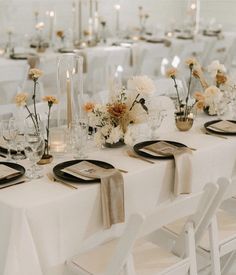 the table is set with white linens and gold place settings