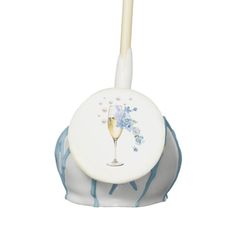 a white and blue toothbrush holder with a glass of wine on it's side