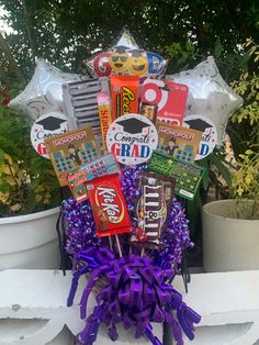 a bouquet of candy, candies and balloons in the shape of graduation caps is sitting on a ledge