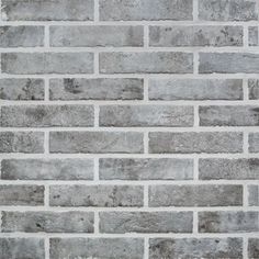 a brick wall that is made out of grey bricks