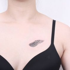 a woman wearing a bra with a feather tattoo on her chest