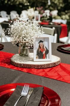 a table topped with a vase filled with white flowers and a photo on top of it