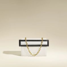 Este bolso minimalista refleja el espíritu de 'BAKO', las tradicionales cajas secretas japonesas.
El marco acolchado distintivo de THE SANT, utilizado como cierre, juega con dos planos superpuestos para lograr un enfoque arquitectónico.
Con dos cierres magnéticos, se puede llevar sobre el hombro con la cadena extraíble o cruzado con la correa larga de cuero.

¿Caben todos tus secretos en él? Modern White Box Bag For Gift, Luxury Rectangular Box Bag For Gift, Rectangular Box Bag For Gifts, Gold Rectangular Minimalist Bag, Gold Minimalist Rectangular Bag, Minimalist Gold Rectangular Bag, White Rectangular Box Bag For Gifts, Elegant Box Bag With Case For Gift, Black Square Box Bag For Gifts