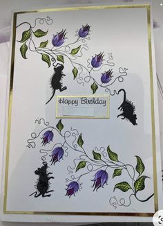 a birthday card with an image of a mouse on the front and purple flowers on the back