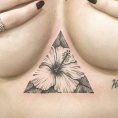 a woman's chest with a flower tattoo on it