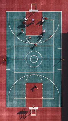 an overhead view of people playing basketball on a court with red tiles and green grass